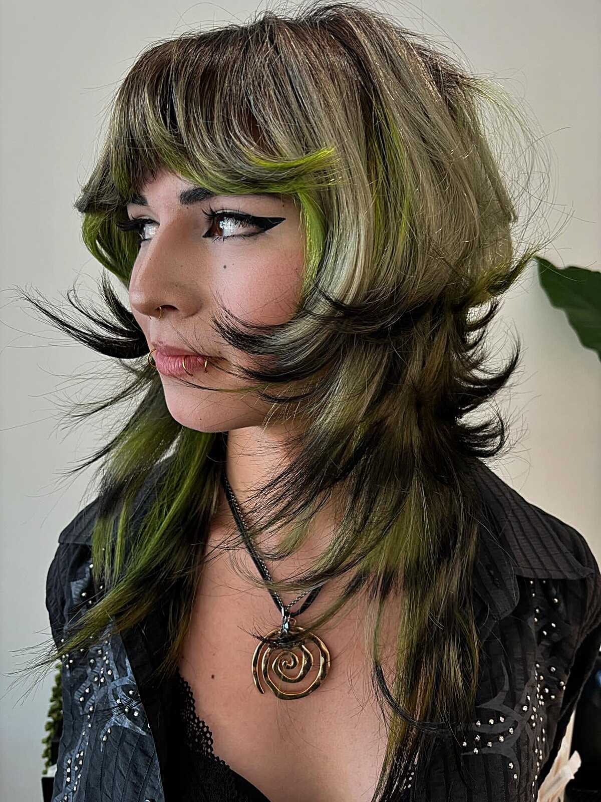 Long layered shag with green streaks over dark brown hair
