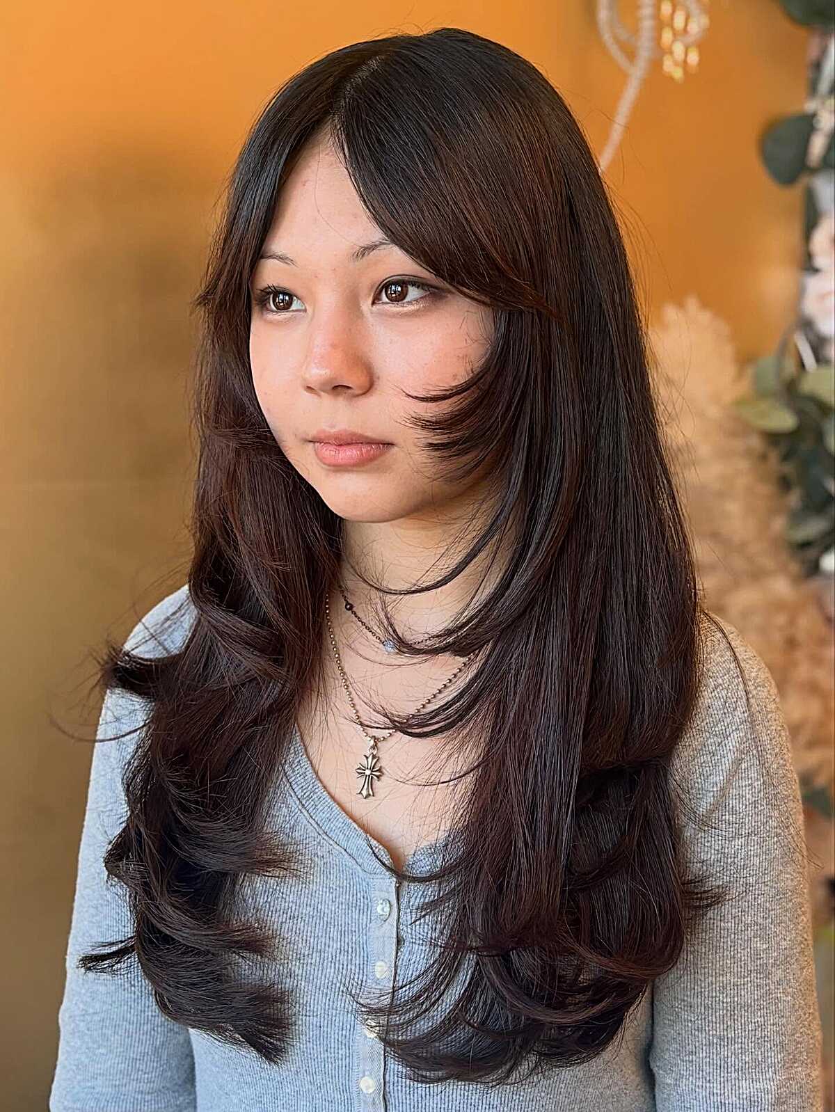 Long sleek dark brown hush cut with side-swept fringe