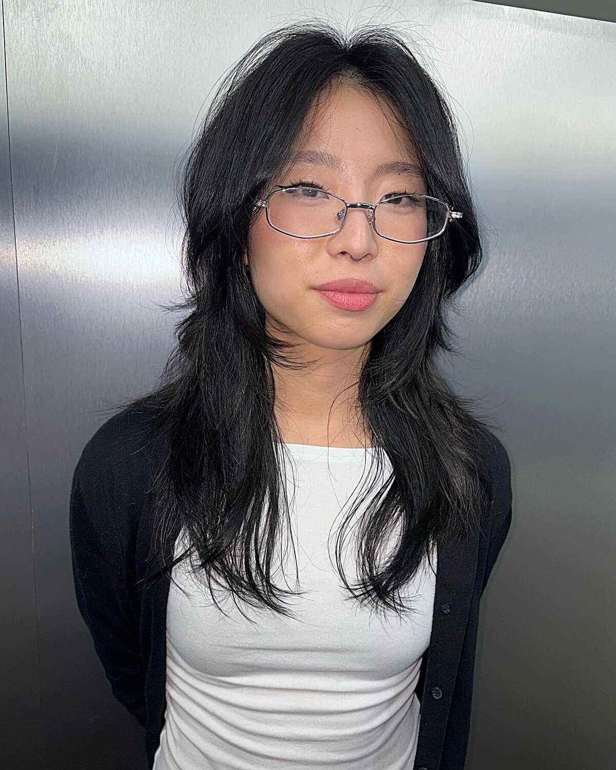 Shoulder-length textured black hush cut with glasses