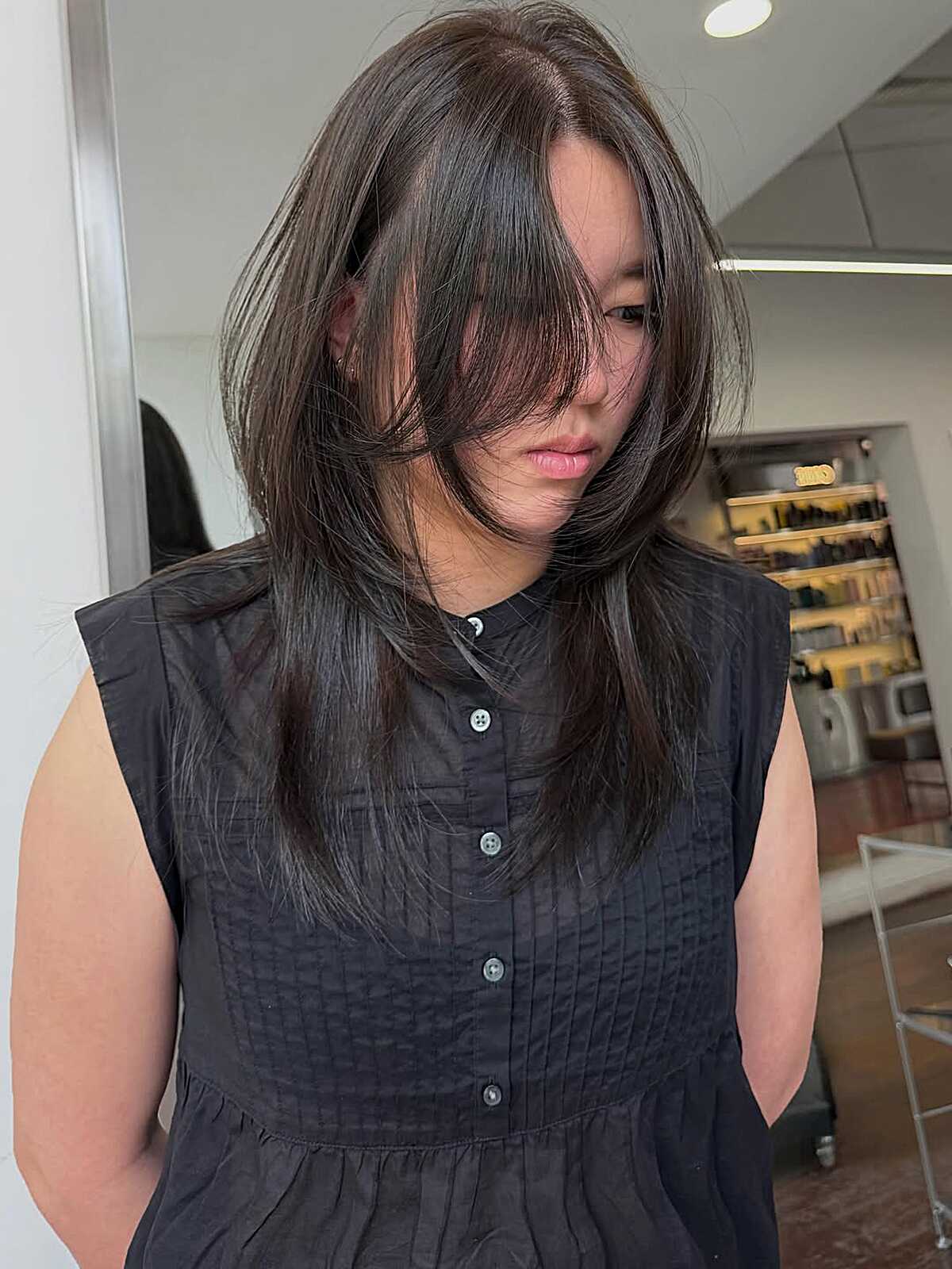 Medium-length brunette hush cut with long side fringe
