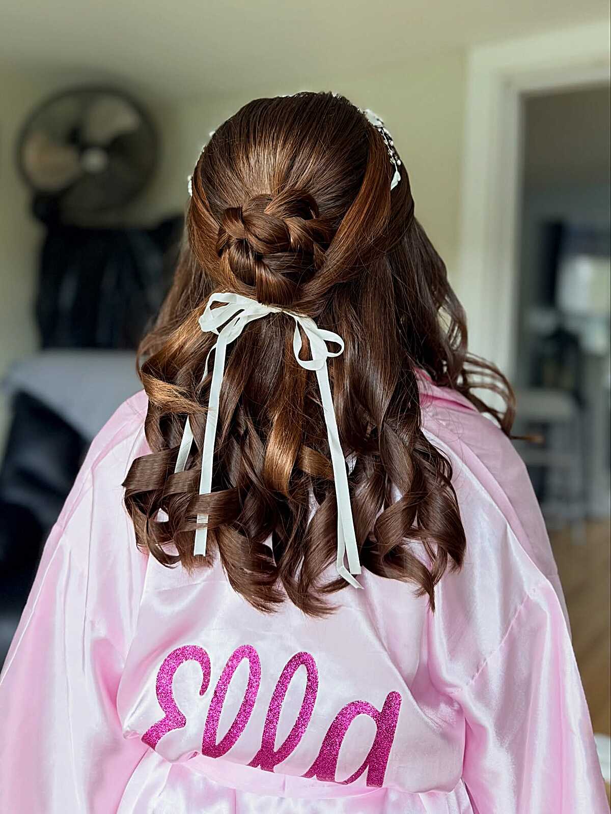 Braided rosette half-down with curls and white ribbon bows