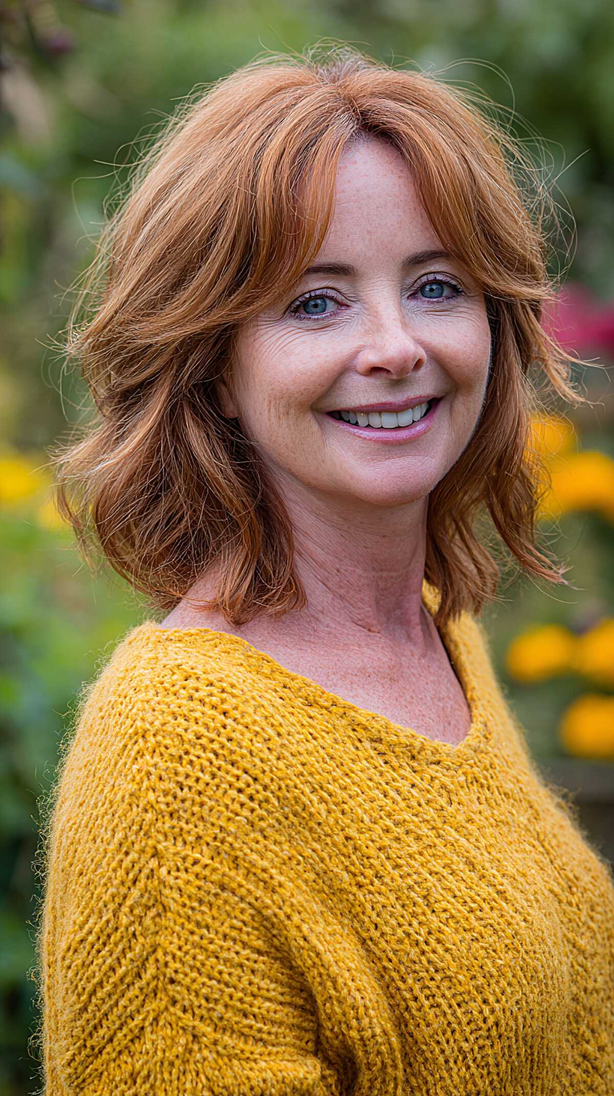 Bright ginger shoulder-length waves with curtain bangs