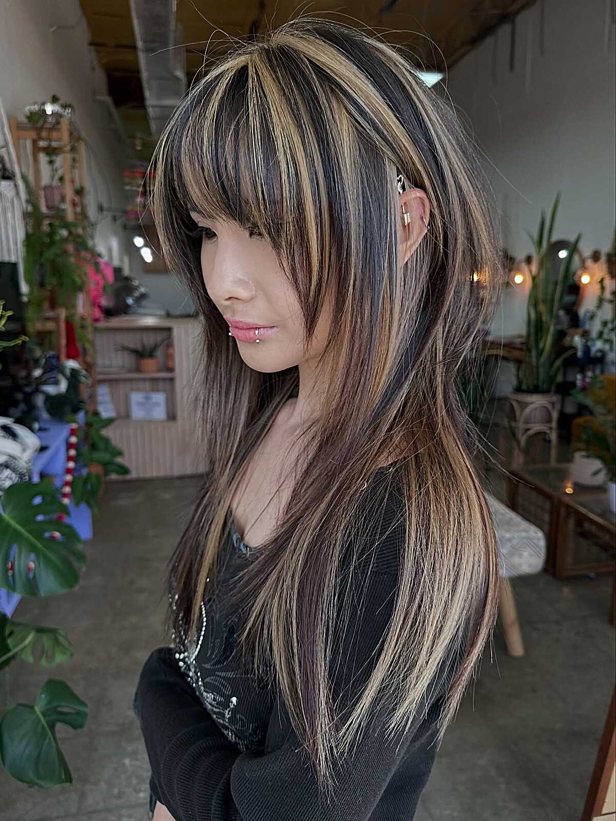 Long dark hair with chunky blonde highlights and bangs