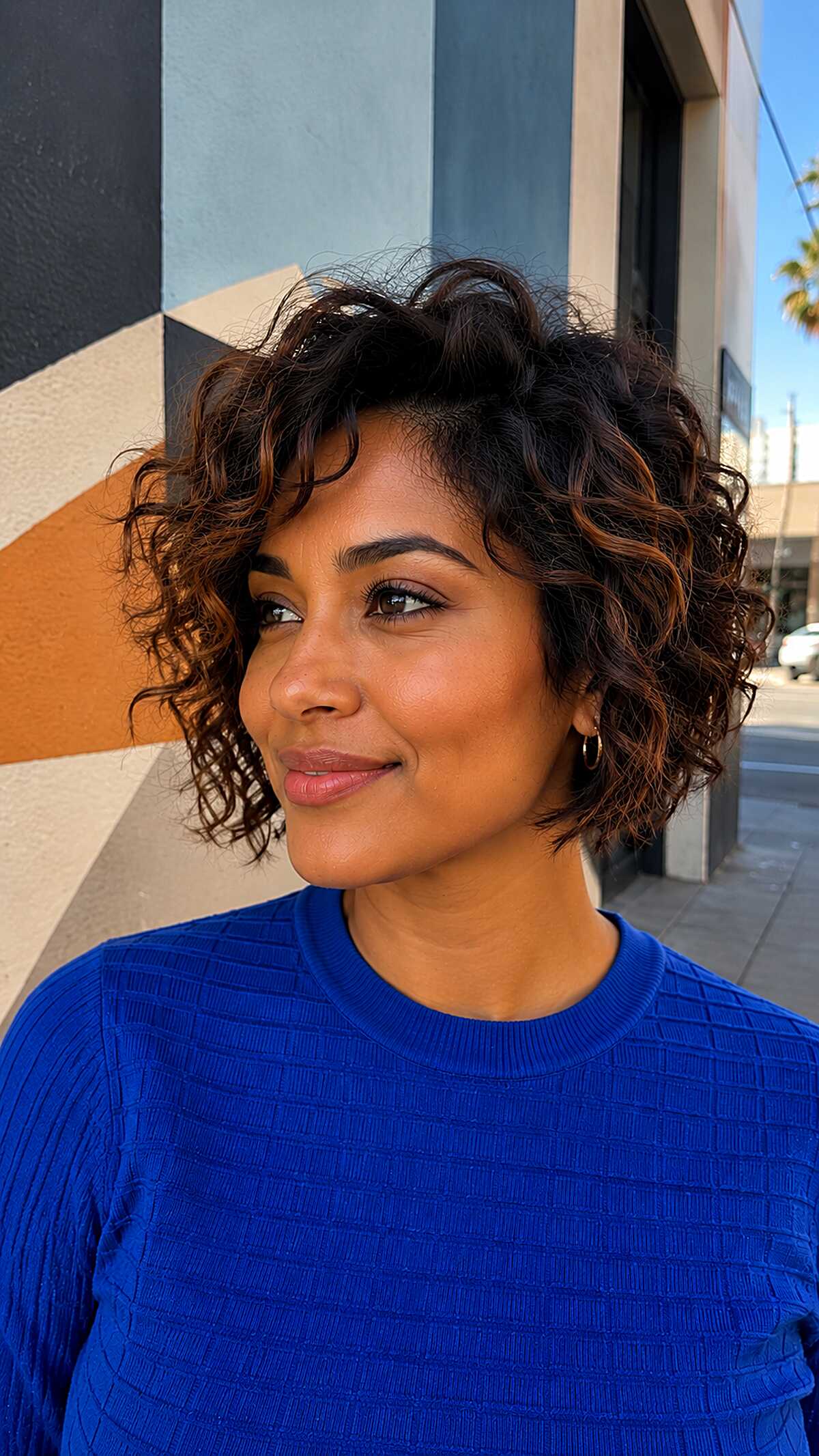 Chin-length curly bob with dark roots and copper ends