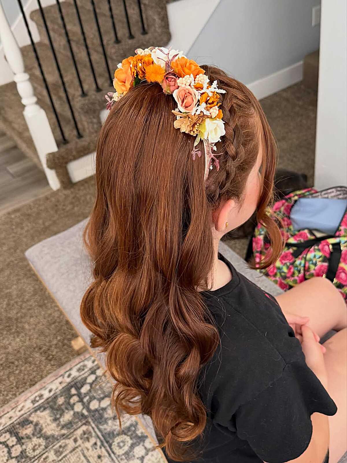 Half-down braid with orange and rust floral crown accent