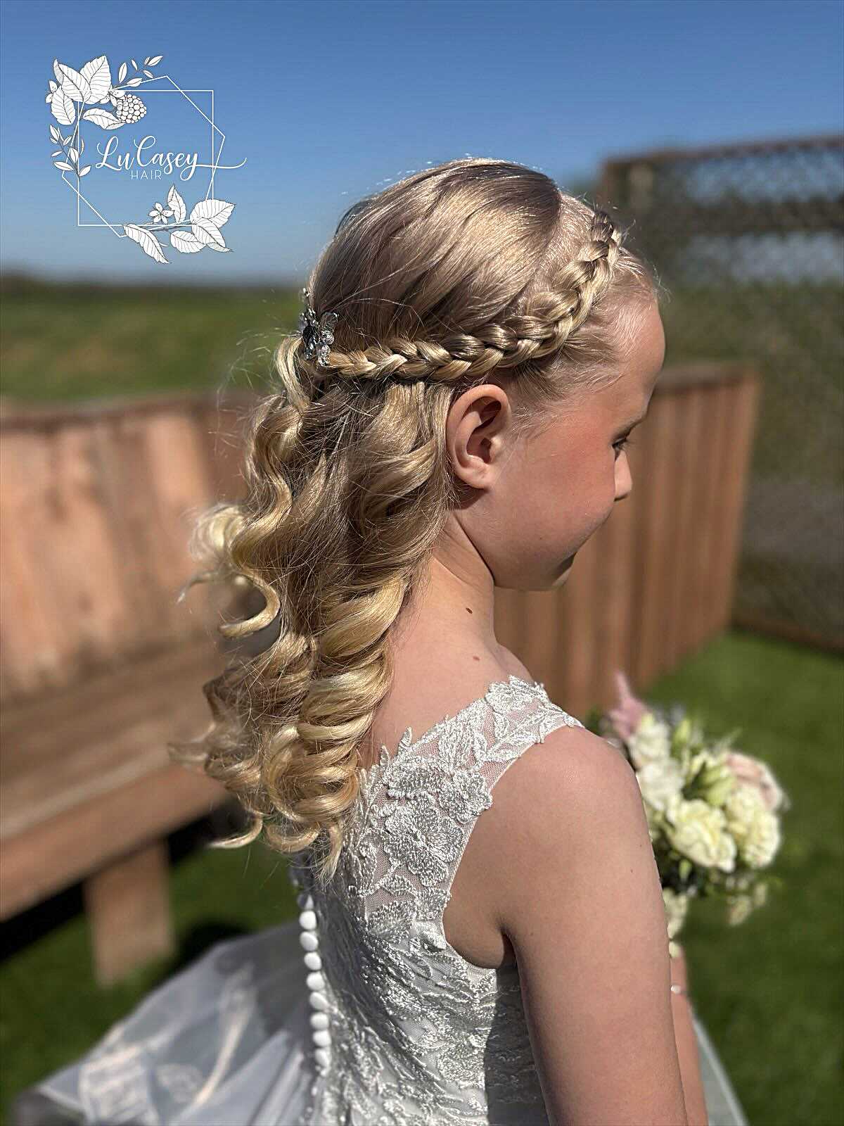 Blonde flower girl with braided crown and long curls