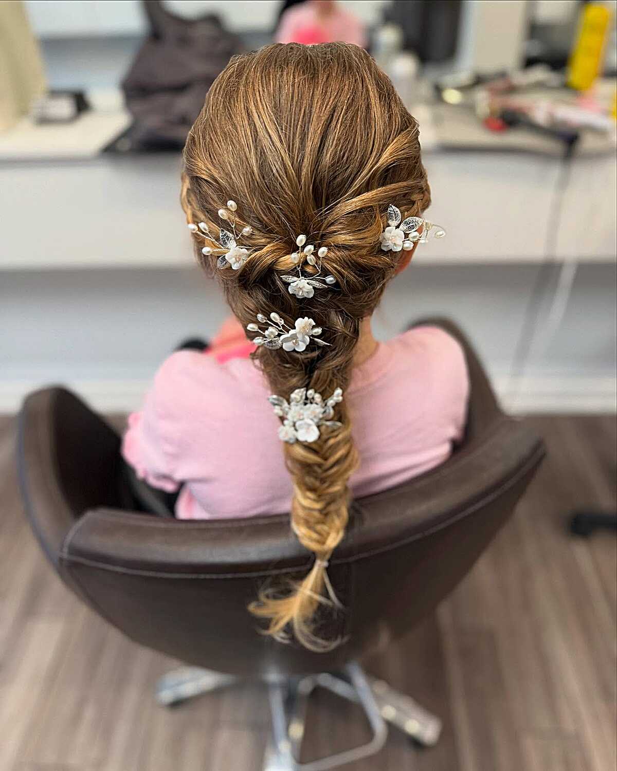 Loose fishtail braid with pearl floral pins throughout