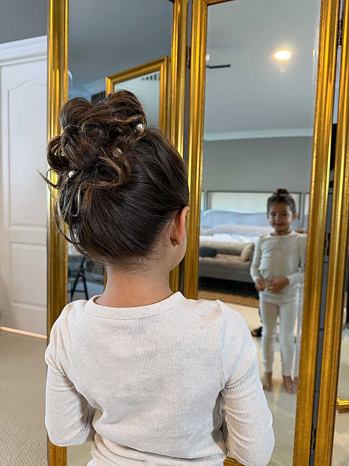 Little girl with textured high bun and small pearl pins