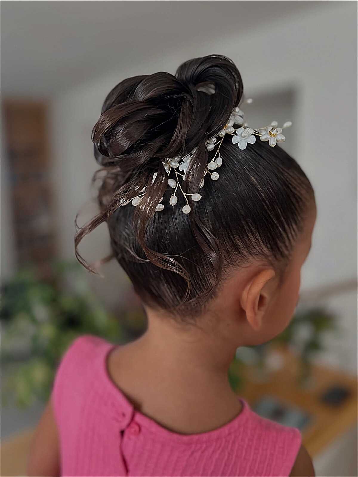 Sleek high bun with curled loops and floral hair vine