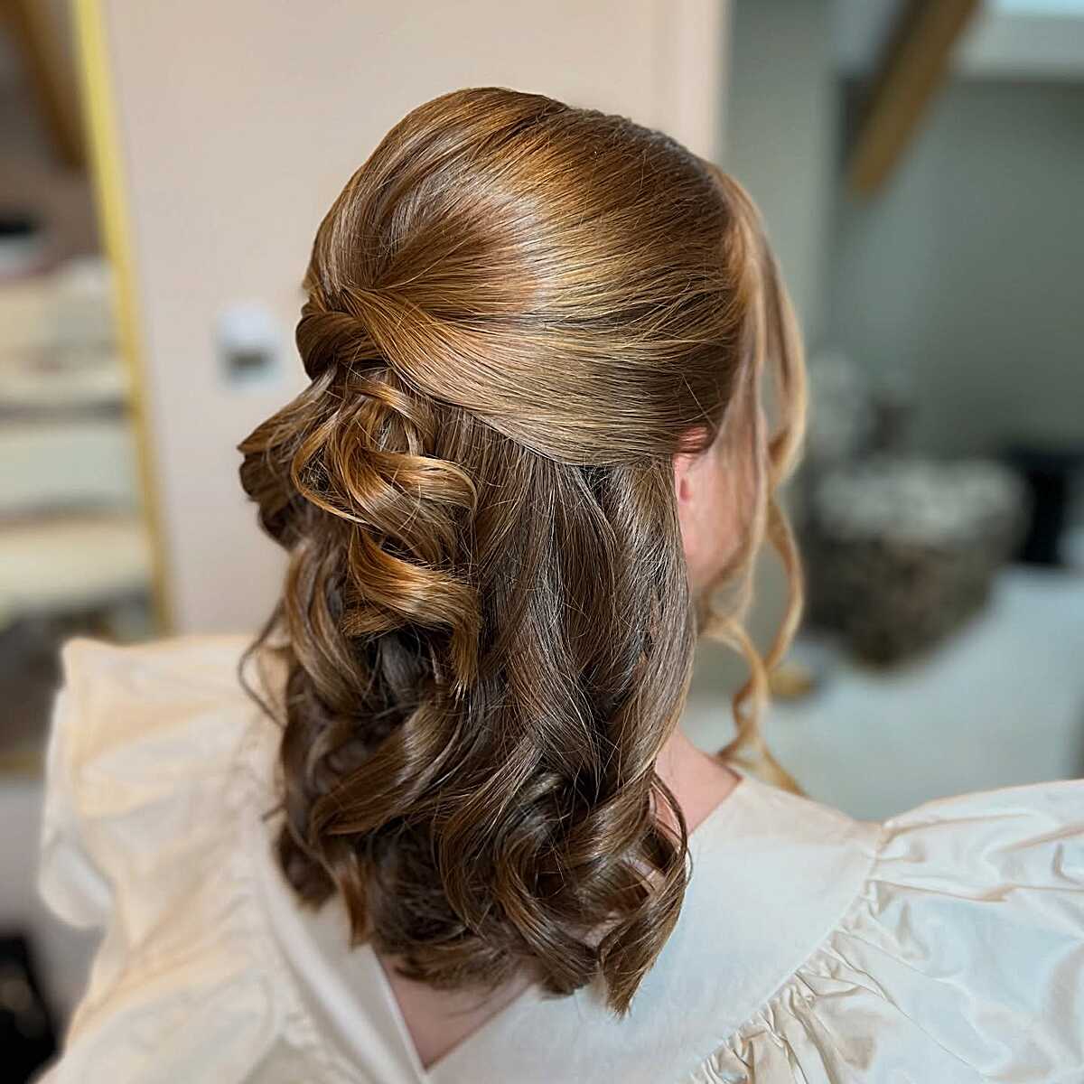 Half-up twisted style with voluminous bouncy curls