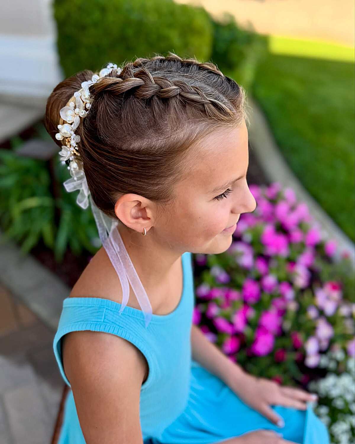 French braid crown wrapping into a low bun with pearl veil