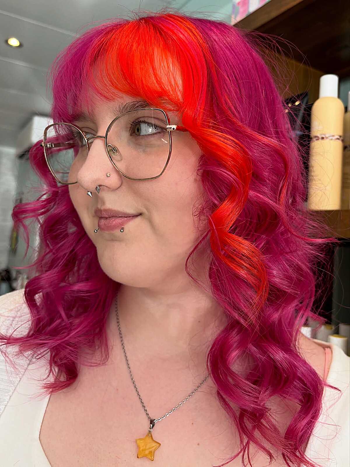Curly hair with hot pink sides and neon orange bangs
