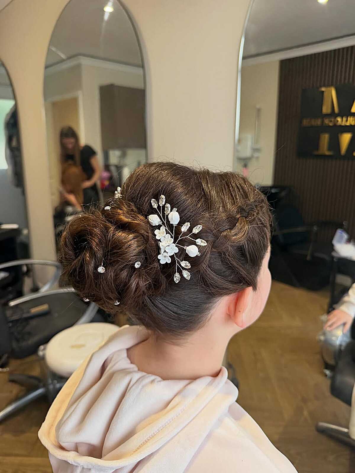 Textured braided chignon updo with crystal floral hair pin
