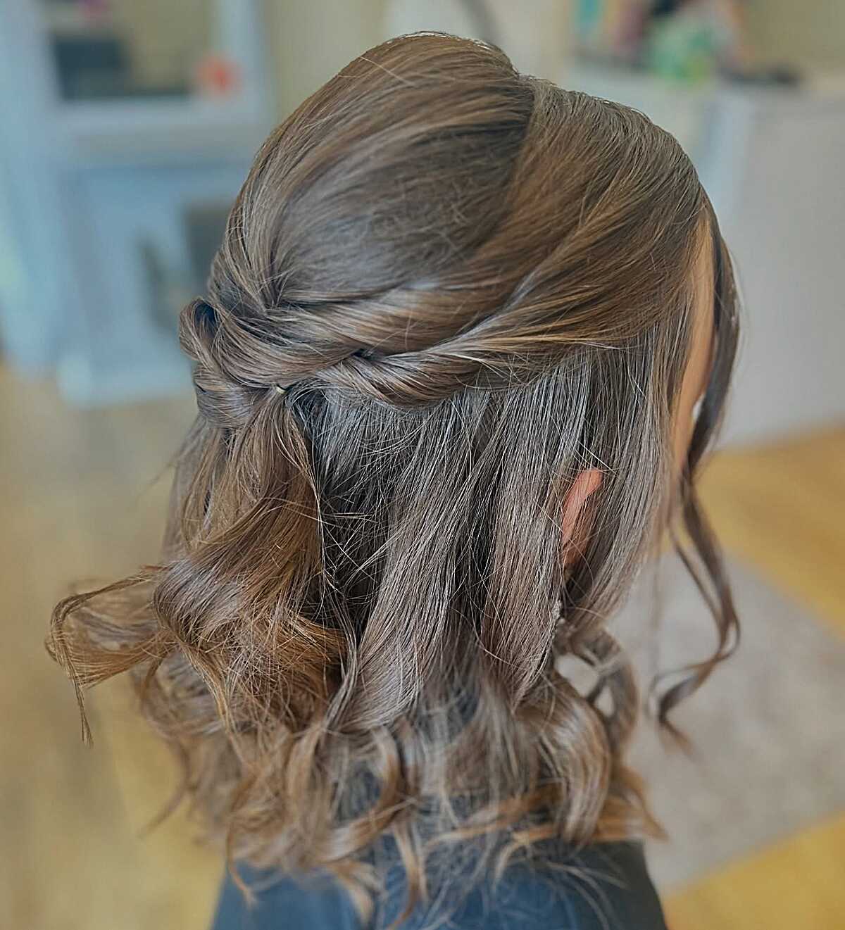 Twisted half-up with loose curls on shoulder-length hair
