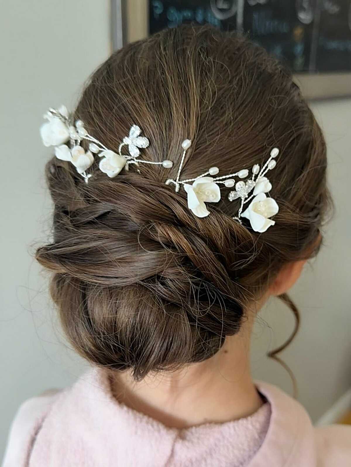 Low chignon with twisted sections and white floral vine