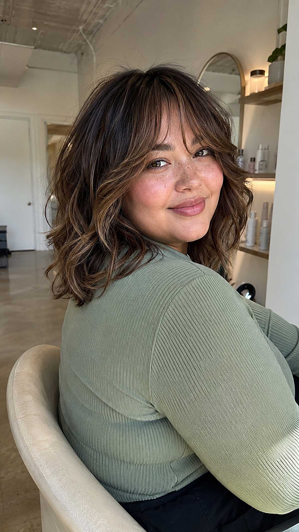 Wavy brunette lob with curtain bangs and soft texture
