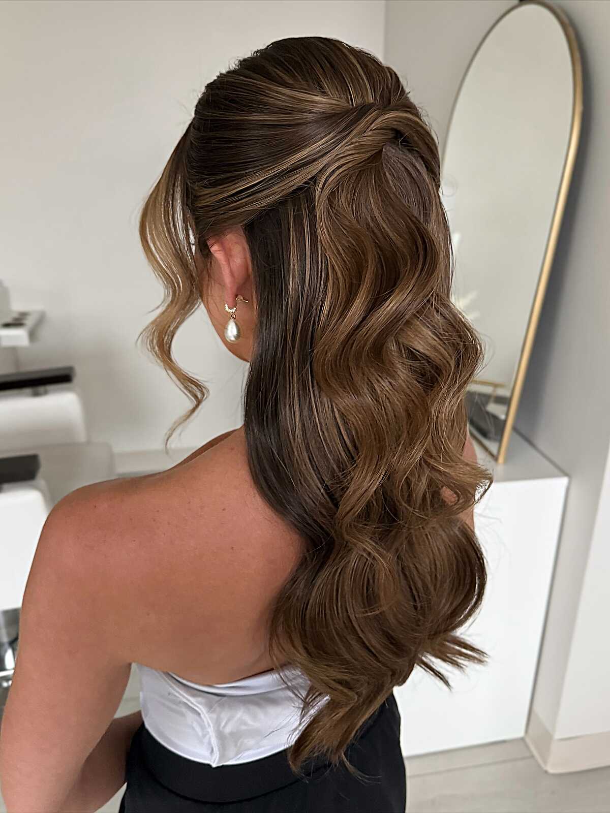Voluminous brunette half up with soft balayage waves