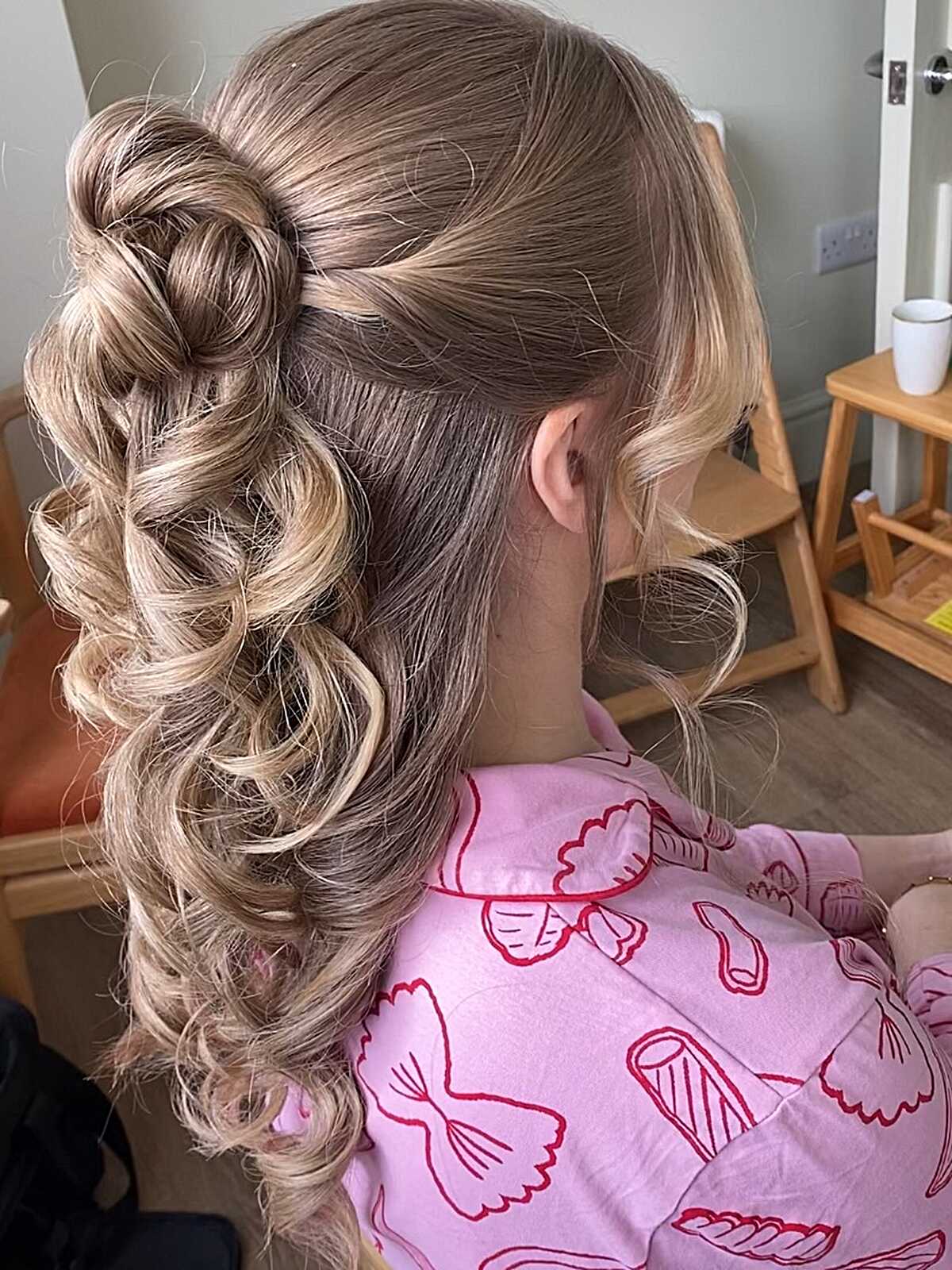 Blonde looped bun half up with soft ringlet curls