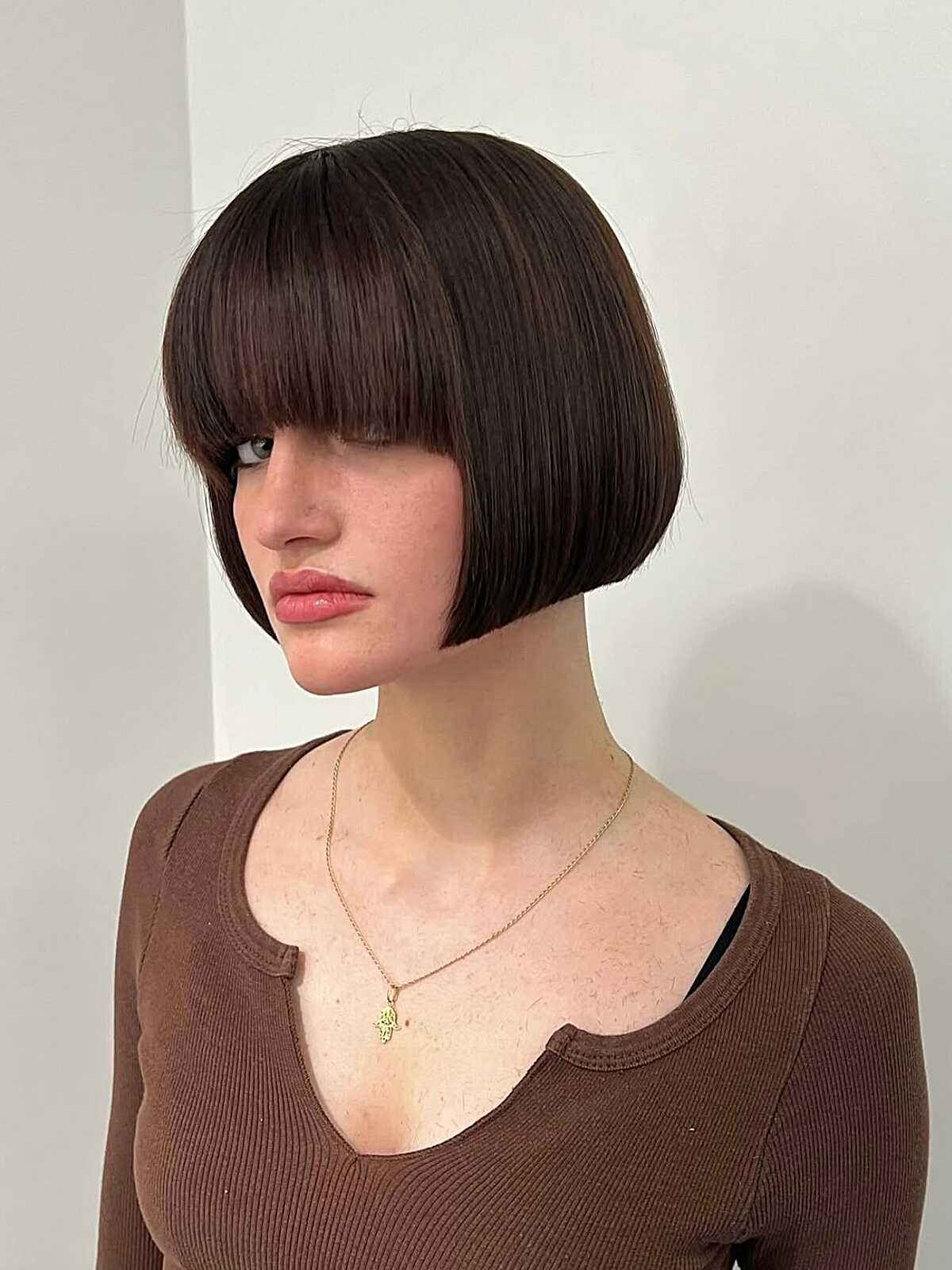 Short dark brown French bob with short straight bangs