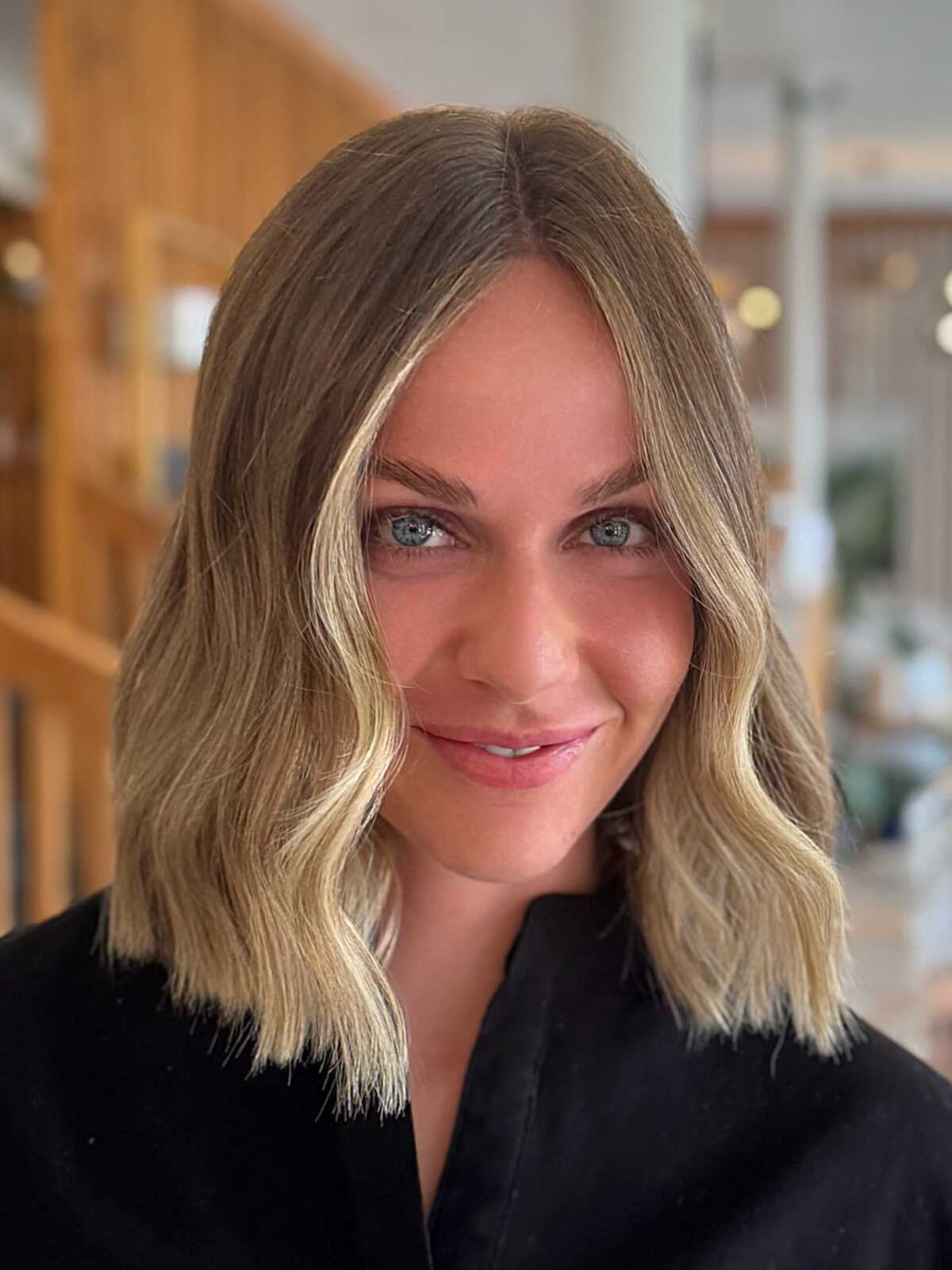 Sandy blonde wavy blunt bob with center part