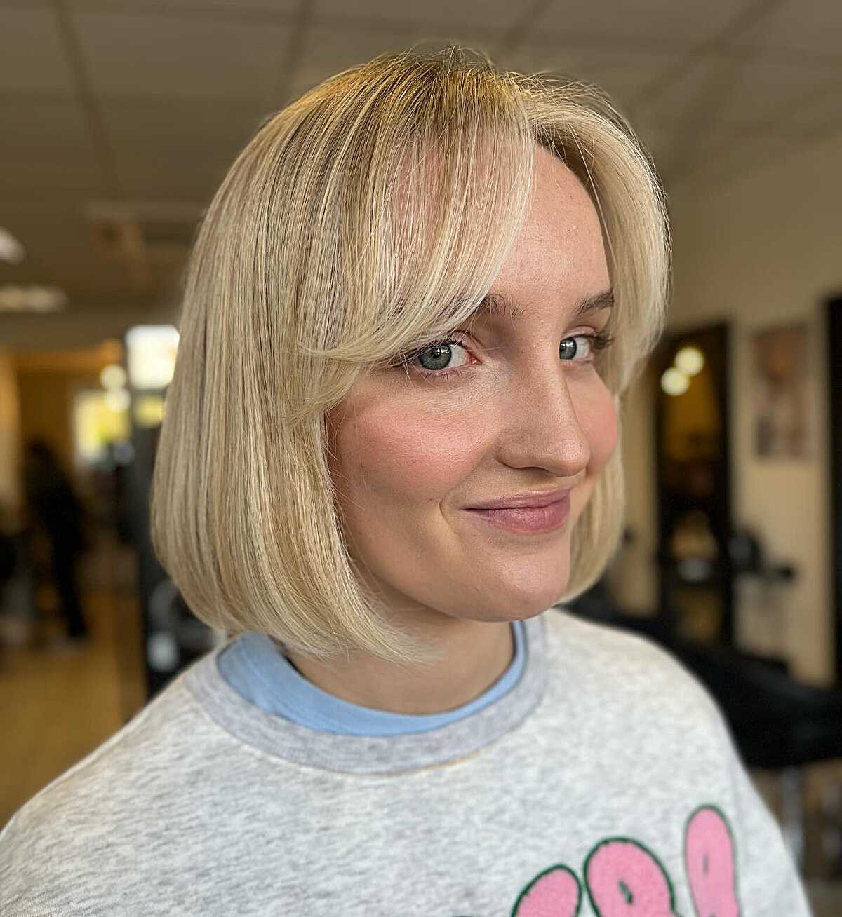 Warm blonde blunt bob with soft side-swept bangs