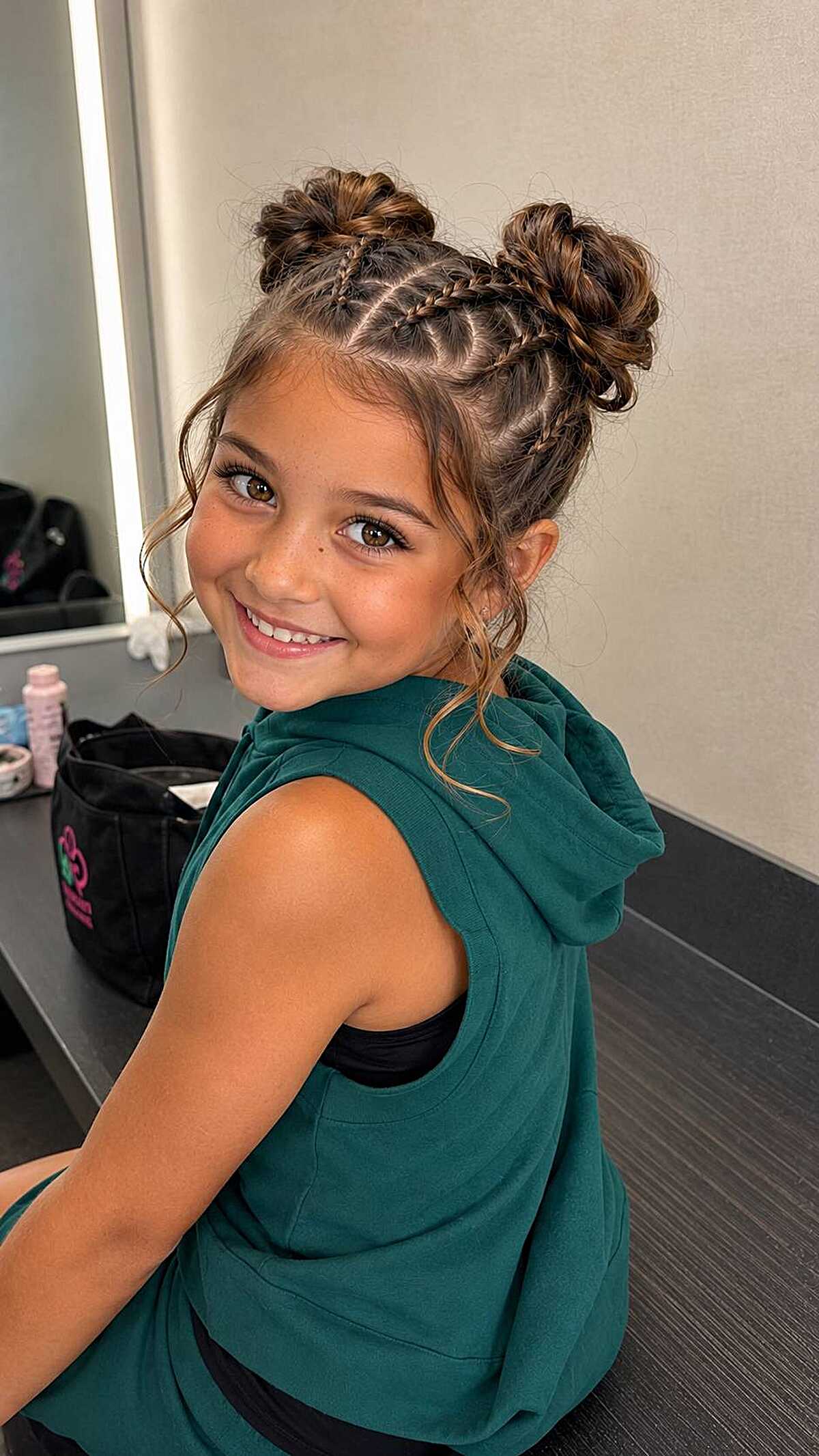 Girl with braided double buns and wispy face-framing hair