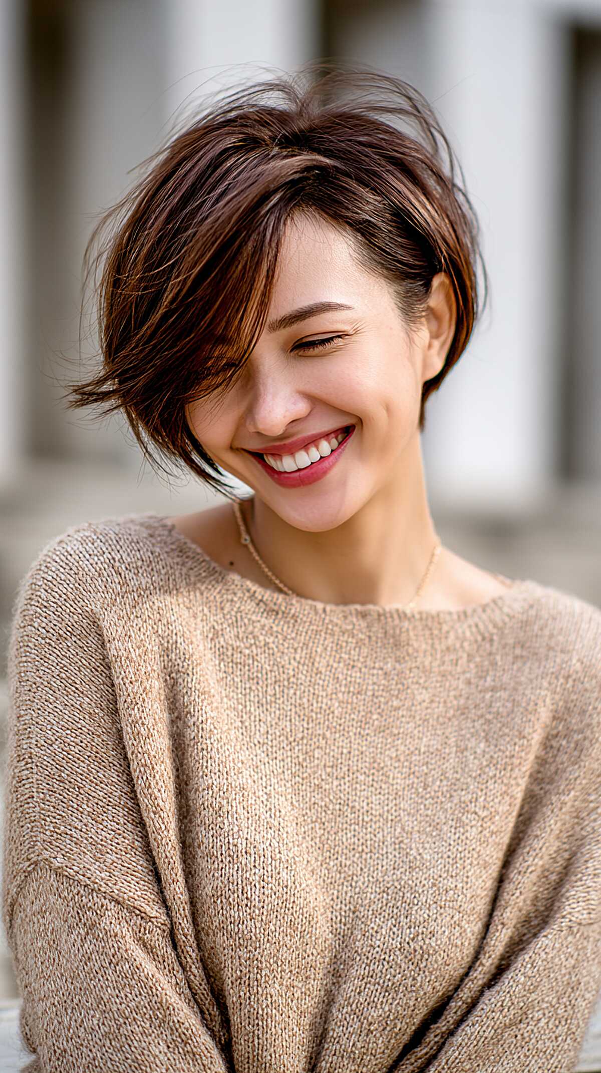 Short dark brown asymmetrical bob with side-swept bangs