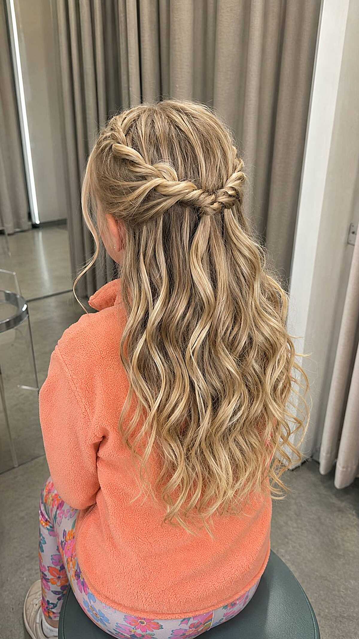Girl with crossed fishtail braids in half-up wavy style