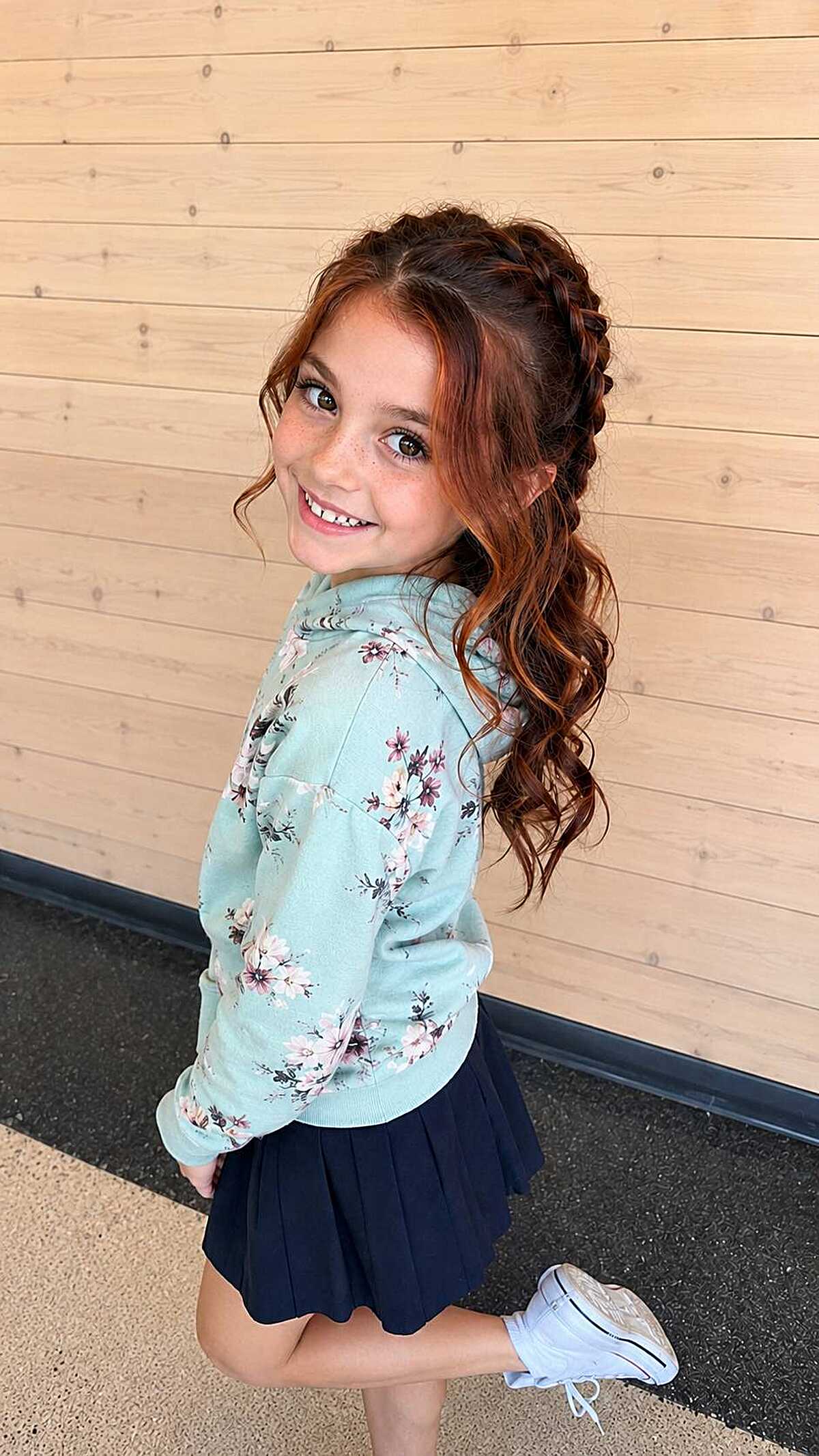 Girl with Dutch braid crown and loose auburn curls