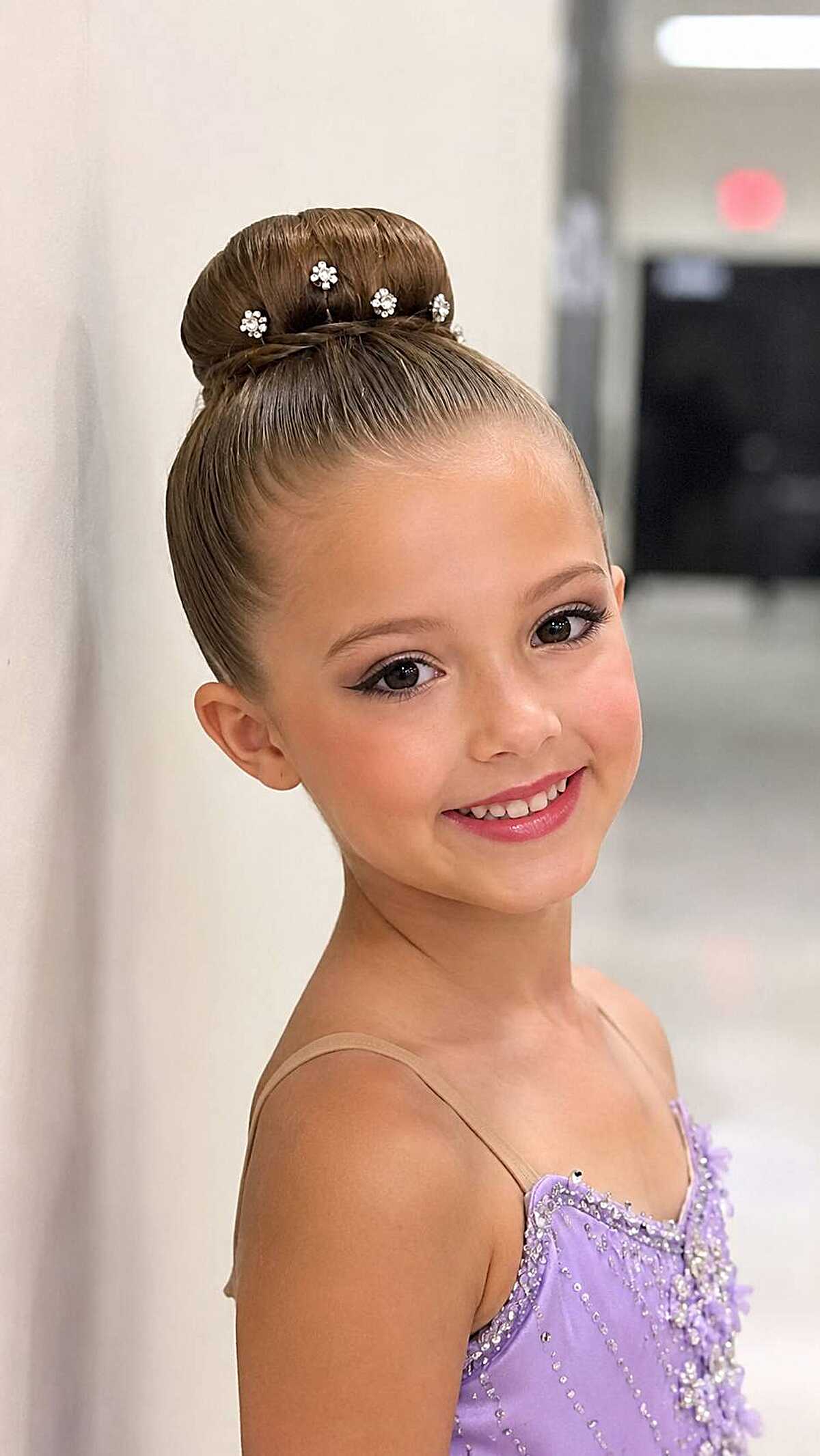 Girl with sleek classic donut bun and crystal pins