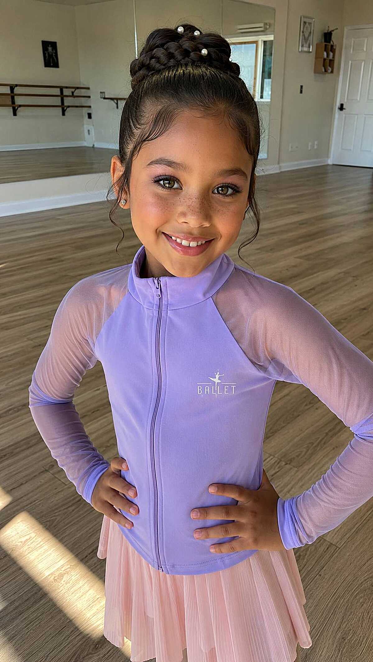 Young ballet dancer with braided bun and pearl pins