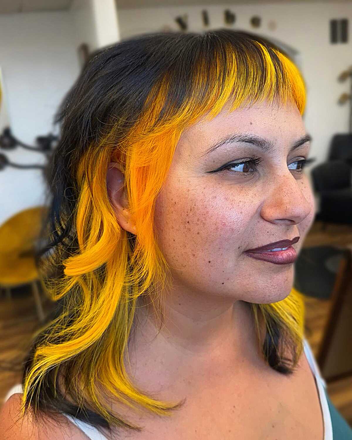 Black shaggy medium cut with bold yellow-orange bangs