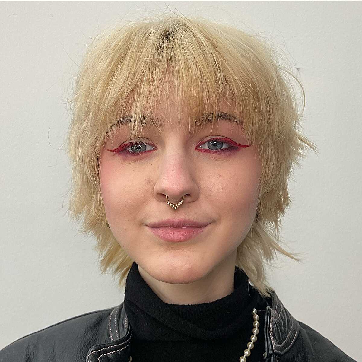 Choppy blonde shag with textured bangs and lived-in layers