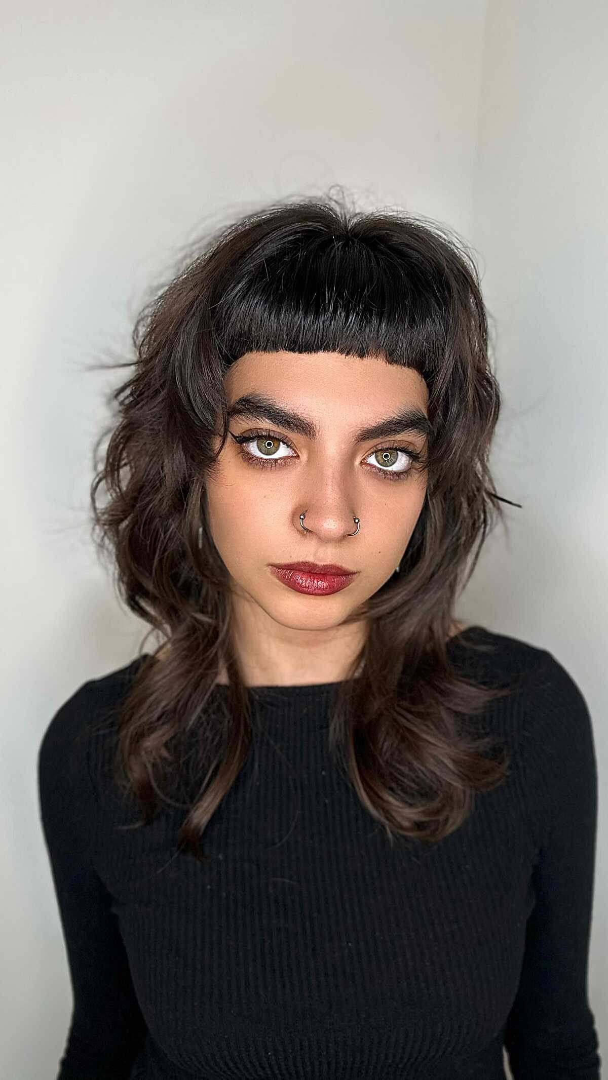 Dark brown shag with blunt micro bangs and loose curls