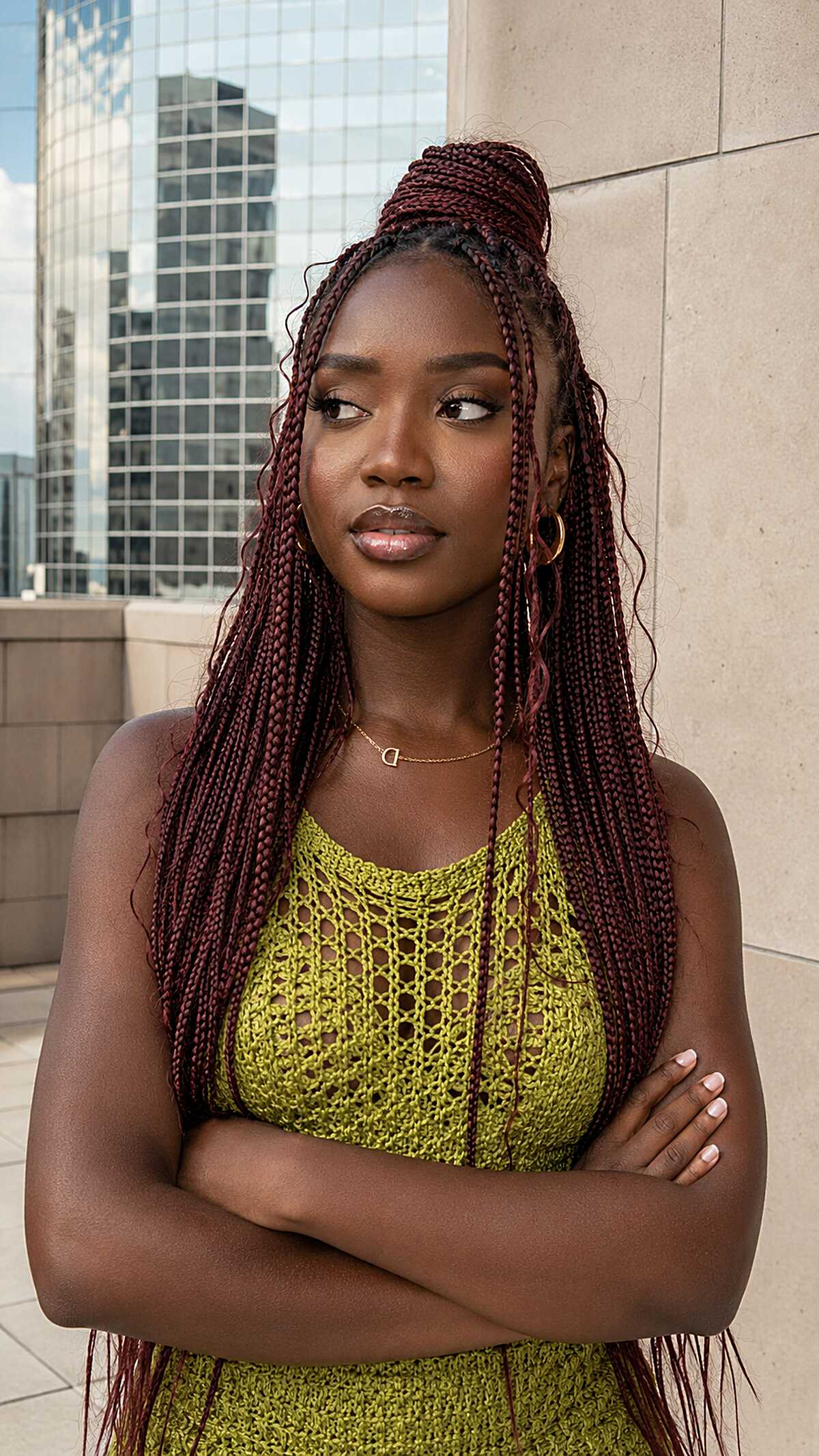 Burgundy knotless braids with a half-up top knot