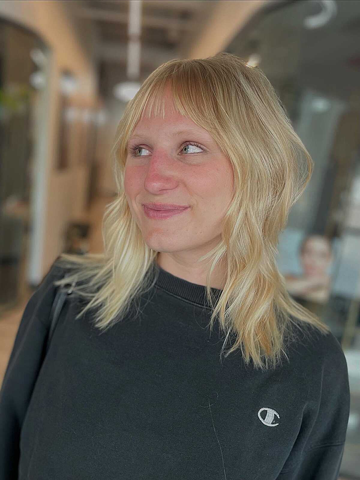 Buttery blonde medium shag with wispy thin bangs