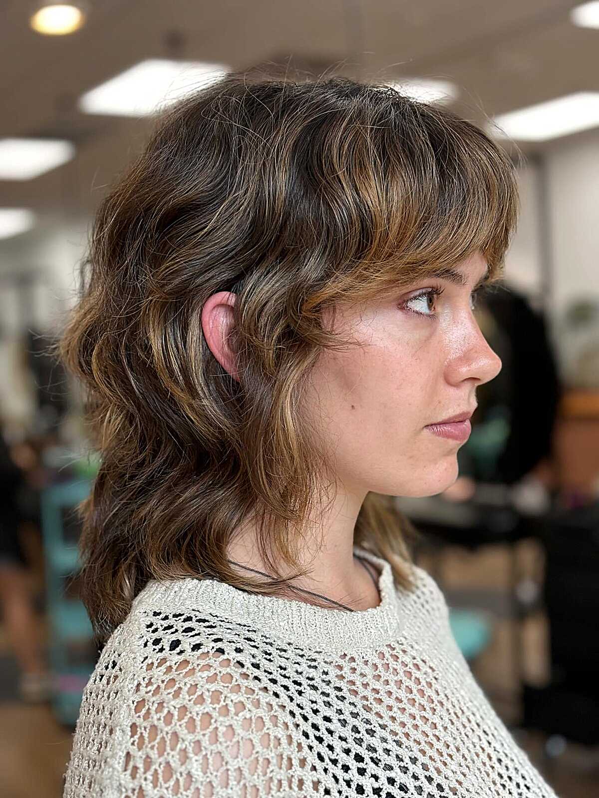 Brown wavy medium shag with caramel highlights and bangs