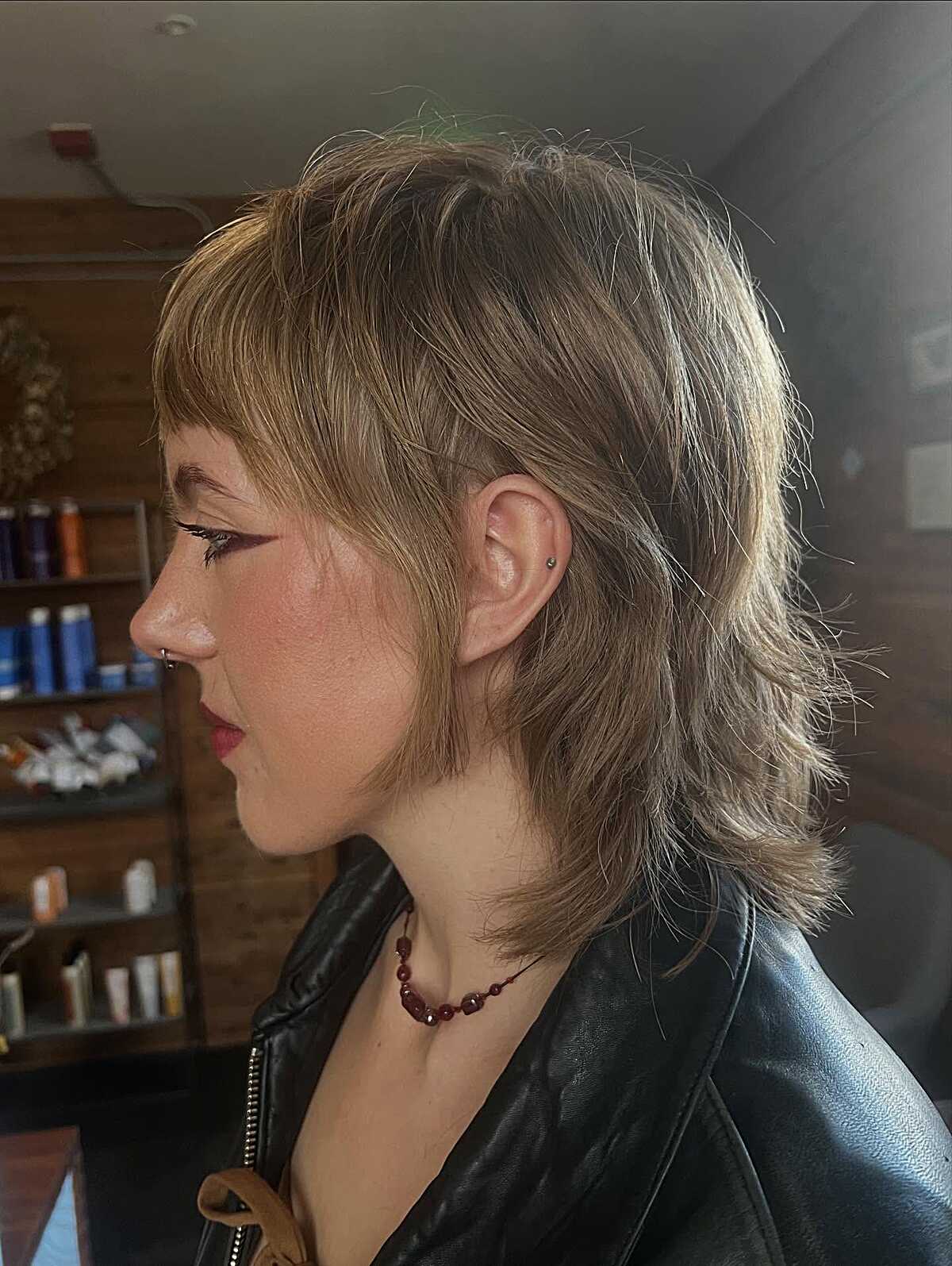Ash blonde choppy shag with short bangs, side profile