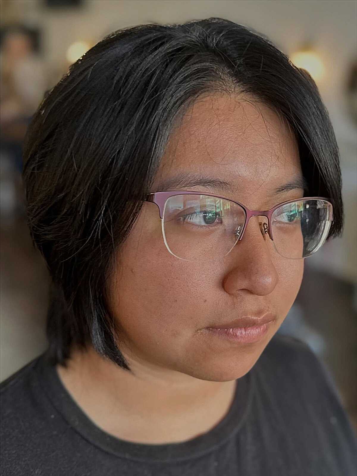 Short black side-parted bob with soft texture and glasses