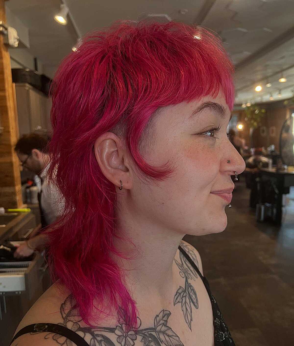 Bright magenta mullet with short bangs and wavy tail