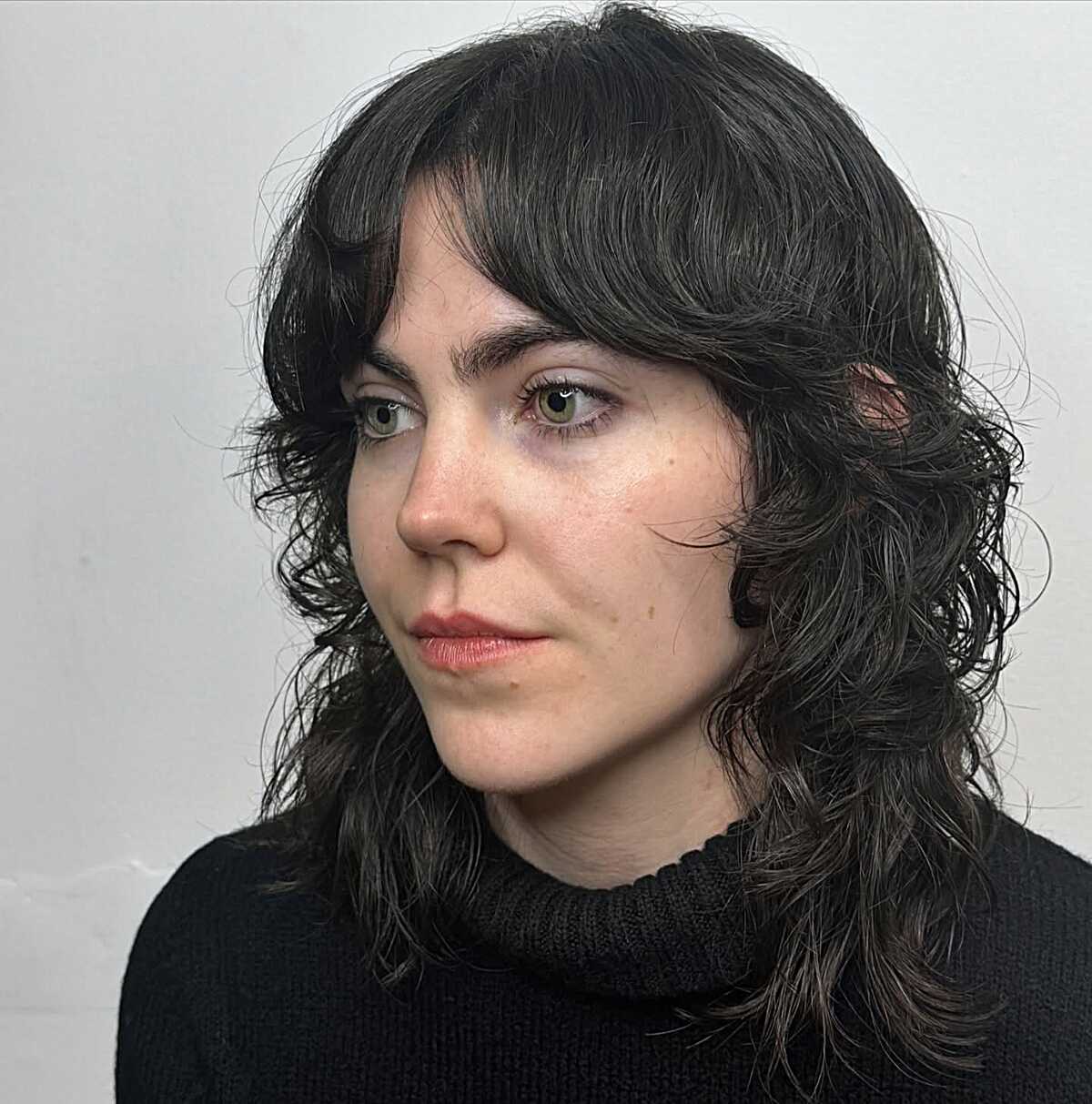 Black wavy shag with curtain bangs at shoulder length
