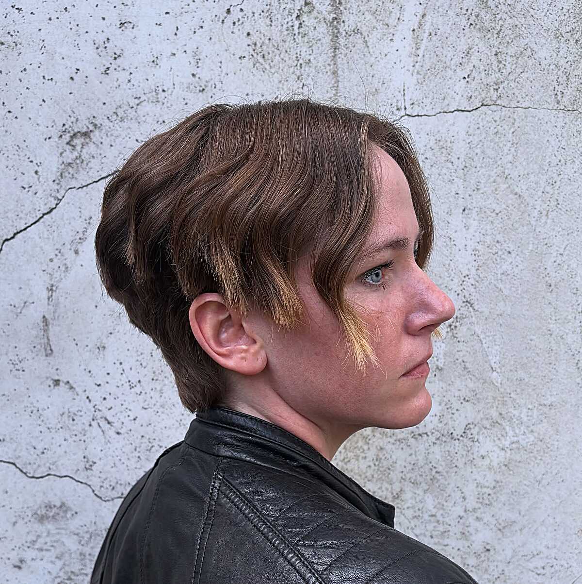 Brown layered bowl cut with honey-blonde tips and leather