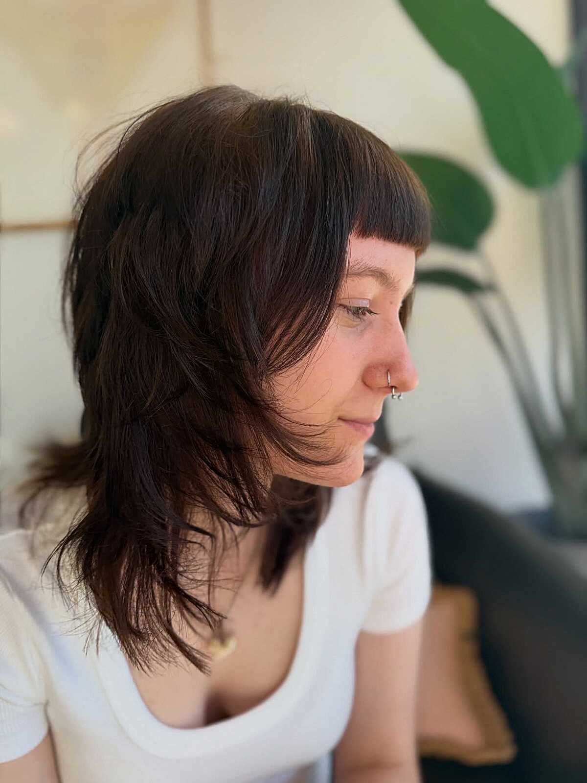 Dark brunette shag with blunt micro bangs and layers