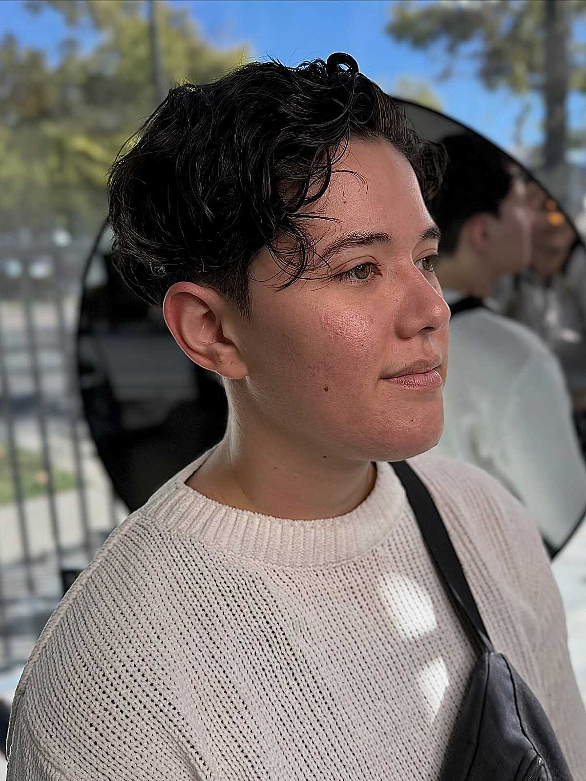 Short black curly pixie with sculpted top and tapered sides