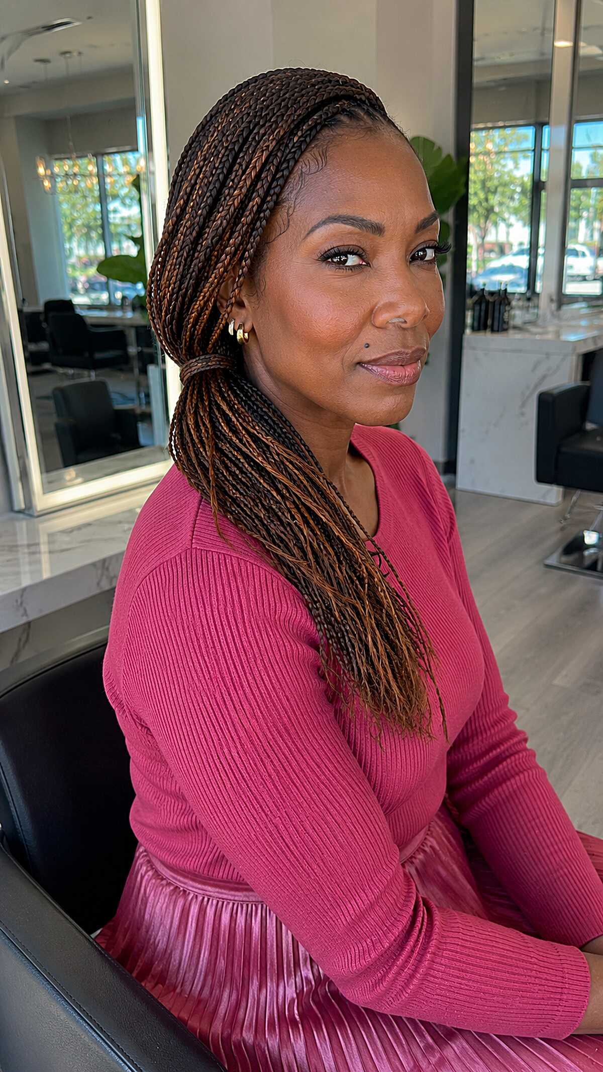 Small black knotless braids swept behind the shoulders