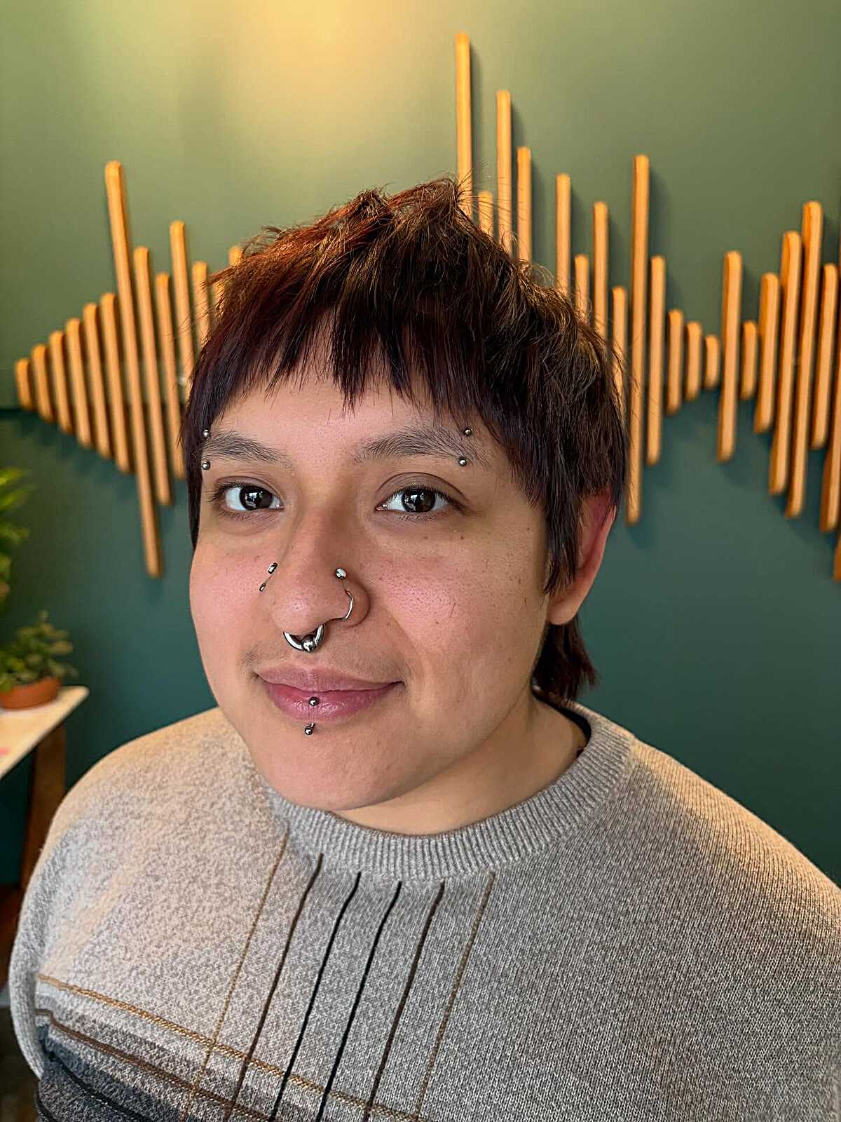 Short dark pixie mullet with reddish-brown highlights