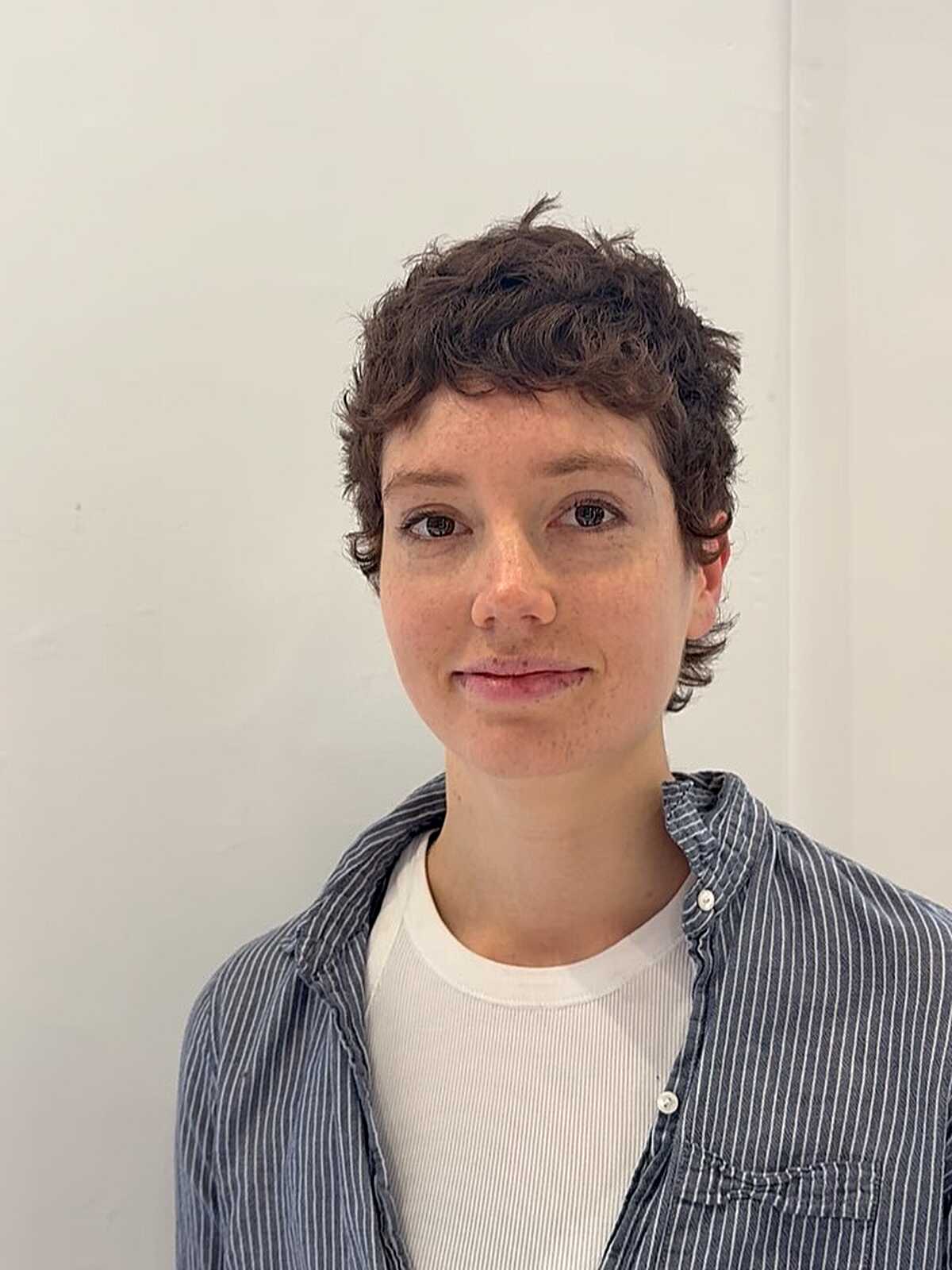 Short tousled curly brown pixie crop with natural texture