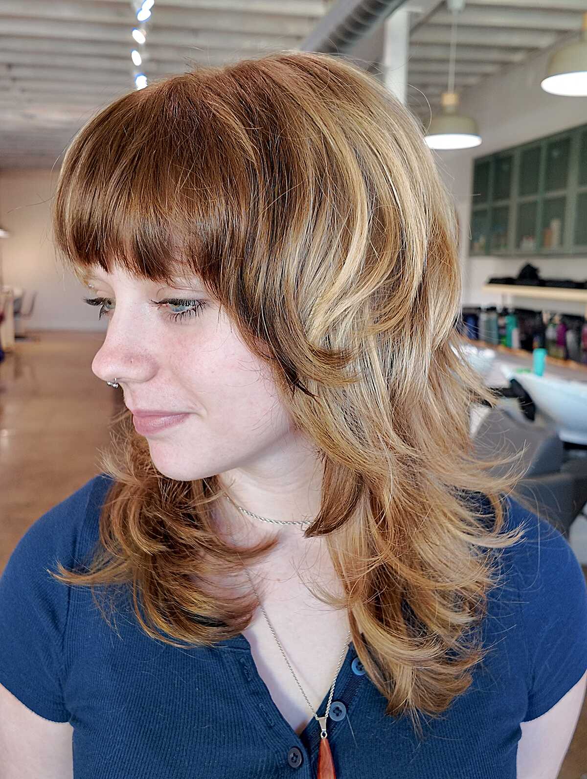 Warm ginger layered shag with full bangs and blown-out waves