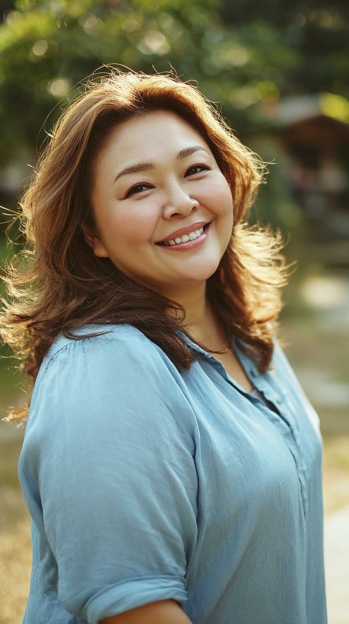 Medium auburn hair with face-framing layers blown outward