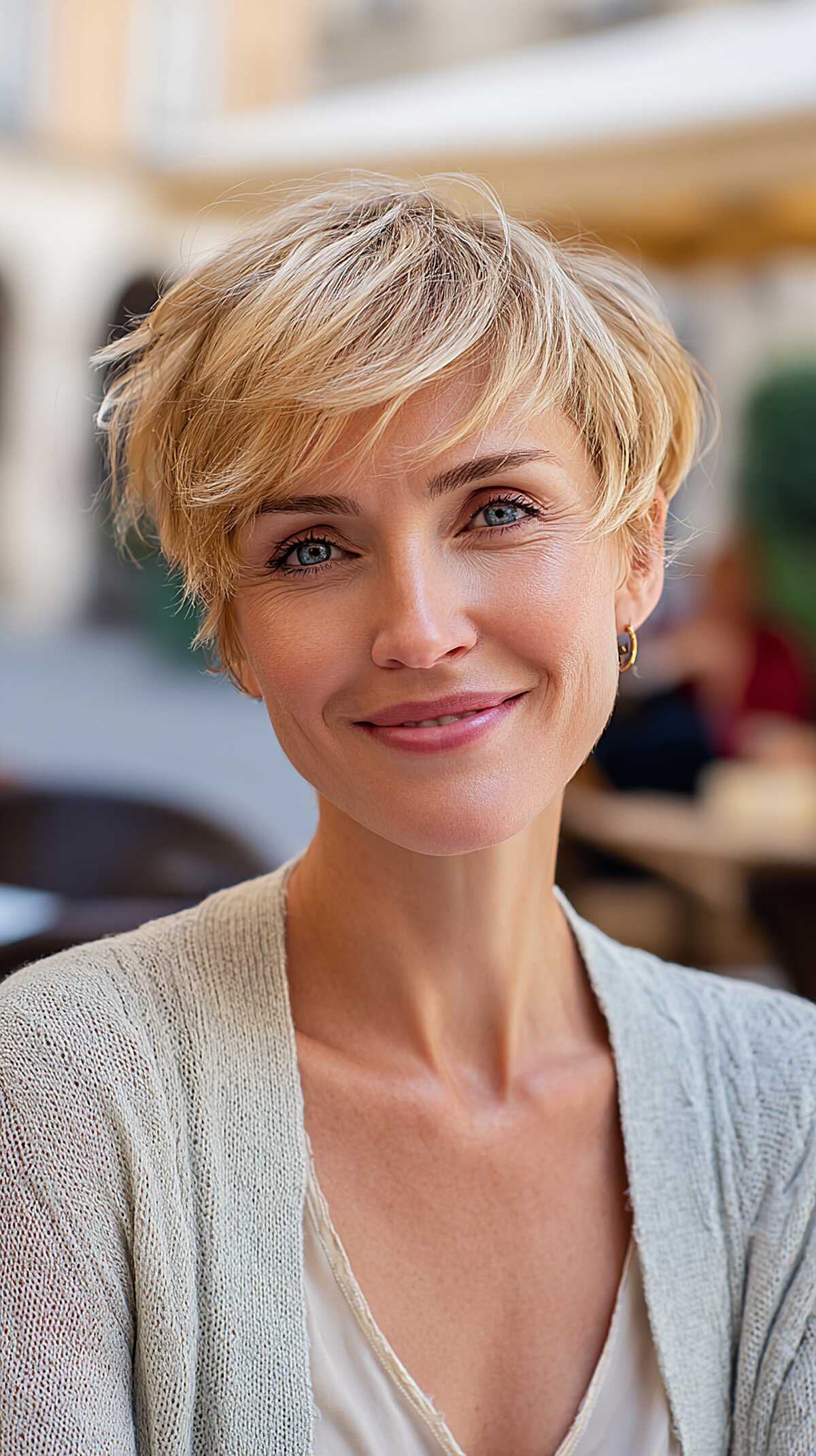 Soft buttery blonde pixie with feathered side-swept fringe